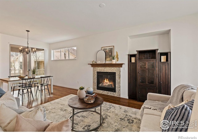 1827 Prairie Ridge Dr, Fort Collins, CO 80526 - living room with baseboards, a notable chandelier, wood finished floors, and a glass covered fireplace