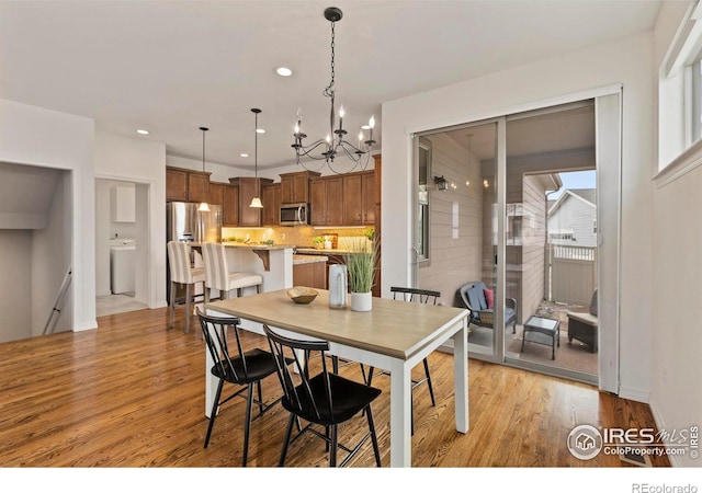 1827 Prairie Ridge Dr, Fort Collins, CO 80526 - dining room with light wood finished floors, recessed lighting, washer / dryer, and an inviting chandelier