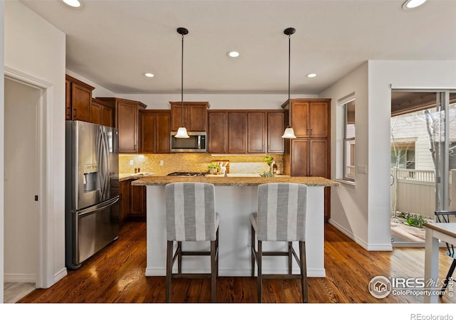 1827 Prairie Ridge Dr, Fort Collins, CO 80526 - kitchen featuring a kitchen island, light stone countertops, decorative backsplash, and stainless steel appliances