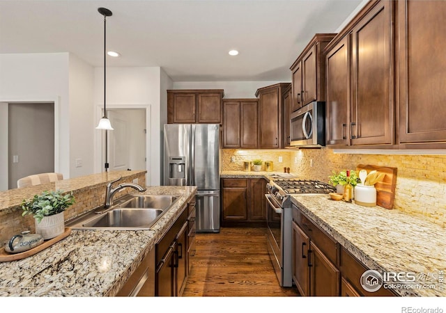 1827 Prairie Ridge Dr, Fort Collins, CO 80526 - kitchen with decorative light fixtures, stainless steel appliances, dark wood-type flooring, backsplash, and a sink