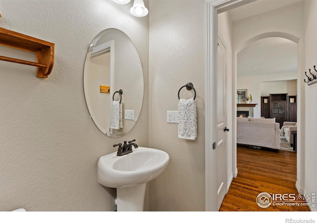 1827 Prairie Ridge Dr, Fort Collins, CO 80526 - bathroom with a textured wall, a lit fireplace, and wood finished floors
