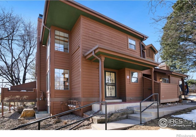 view of front of property featuring a chimney and a porch