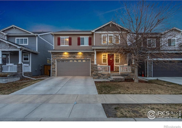 view of front of home with stone siding, a porch, a garage, and concrete driveway