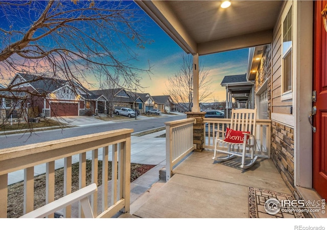 patio terrace at dusk with a porch and a residential view