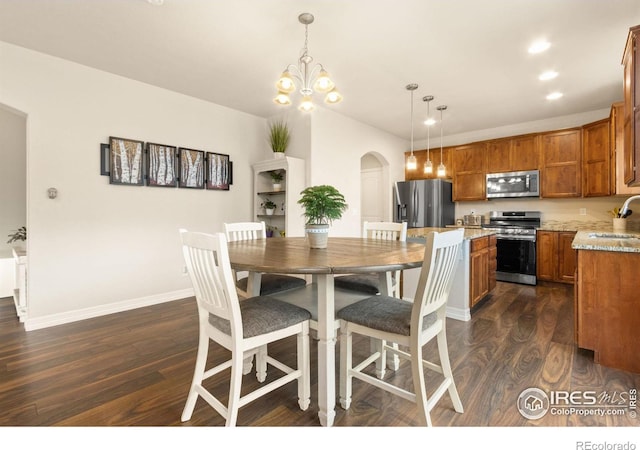 dining room with dark wood finished floors, baseboards, arched walkways, and recessed lighting