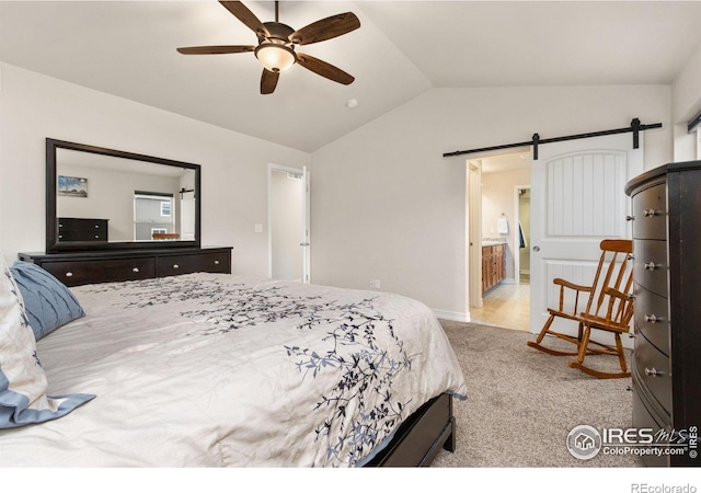 carpeted bedroom with a barn door, lofted ceiling, ceiling fan, and connected bathroom