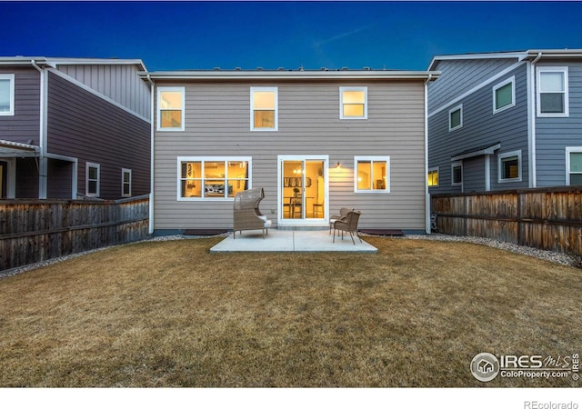 back of house featuring a fenced backyard, a yard, and a patio area