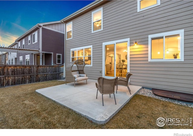 back of property featuring fence and a patio