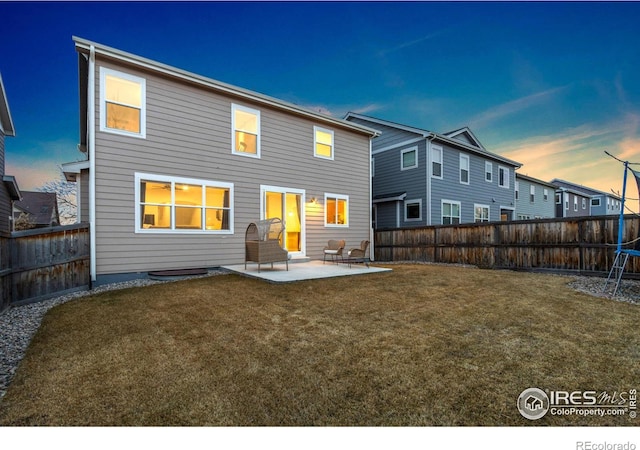 back of house with a lawn, a fenced backyard, and a patio area