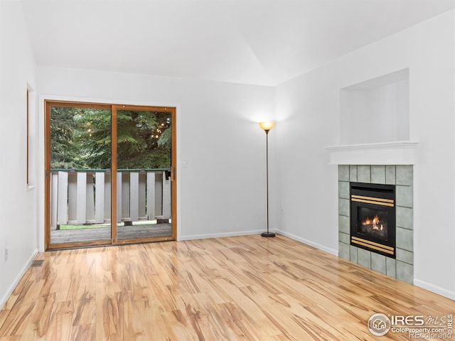 1010 S Saint Vrain Ave S, Estes Park, CO 80517 - unfurnished living room featuring a tile fireplace, wood finished floors, lofted ceiling, and baseboards