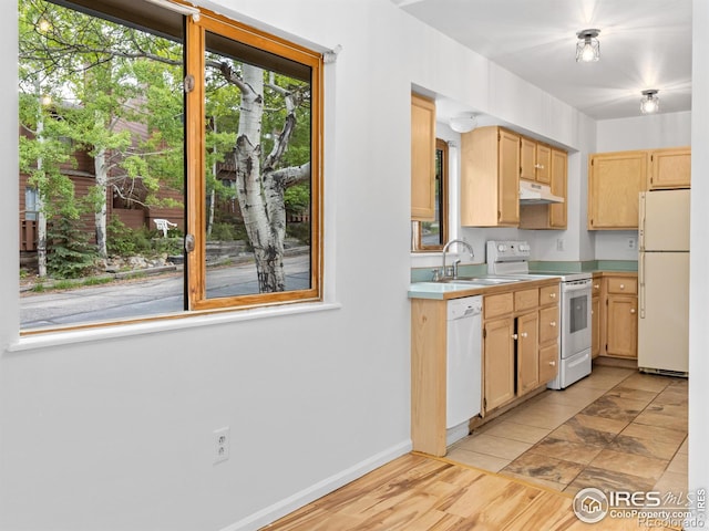 1010 S Saint Vrain Ave S, Estes Park, CO 80517 - kitchen featuring white appliances, a sink, light brown cabinetry, under cabinet range hood, and light countertops