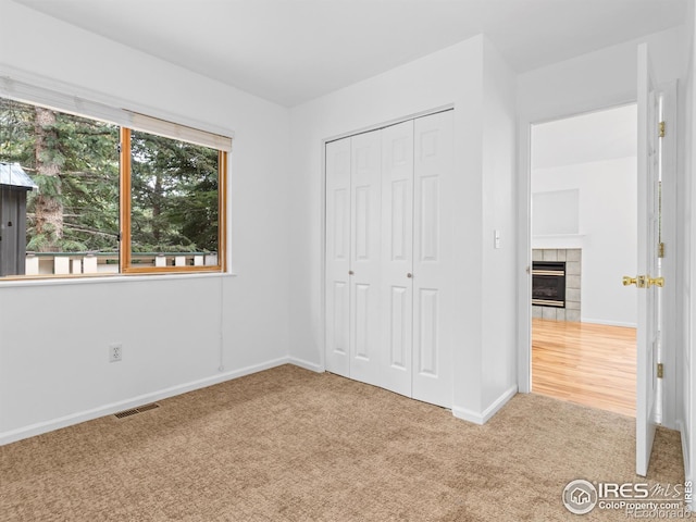 1010 S Saint Vrain Ave S, Estes Park, CO 80517 - unfurnished bedroom with carpet, a tiled fireplace, baseboards, and a closet