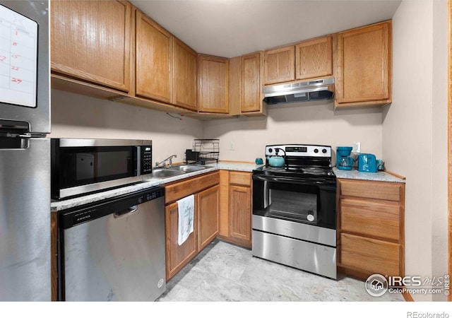 1640 Kirkwood Dr Unit 2011, Fort Collins, CO 80526 - kitchen with under cabinet range hood, light countertops, a sink, and stainless steel appliances