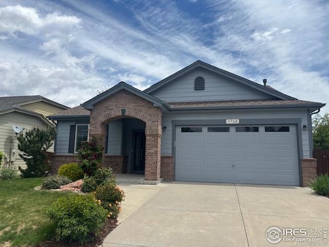 5768 Quarry St, Timnath, CO 80547 - view of front of property featuring brick siding, driveway, and a garage