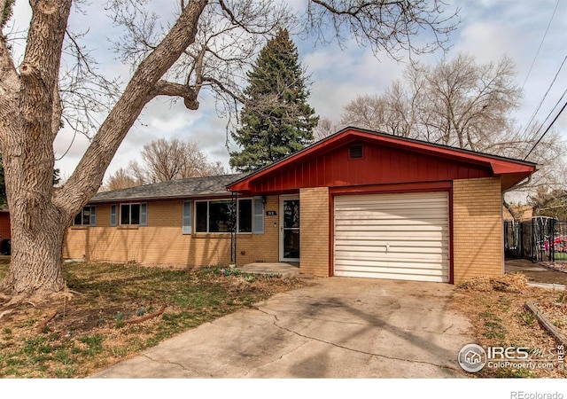 view of front of home with fence, a garage, brick siding, and concrete driveway