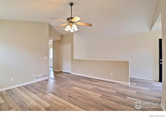 unfurnished room featuring a ceiling fan, visible vents, lofted ceiling, light wood finished floors, and baseboards