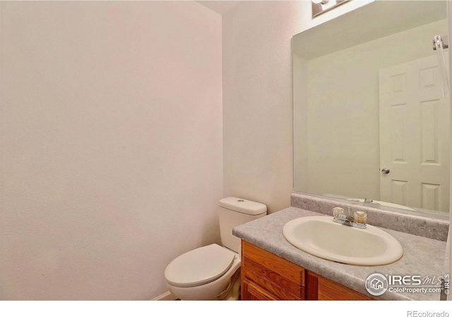 half bath featuring toilet and vanity
