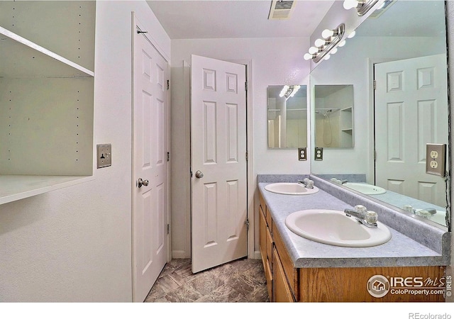 full bath with double vanity, visible vents, and a sink