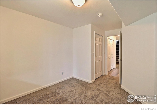 empty room featuring carpet flooring and baseboards