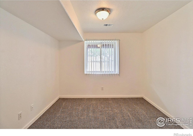 unfurnished room featuring visible vents, baseboards, and carpet