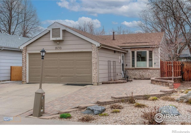 ranch-style home with roof with shingles, concrete driveway, fence, an attached garage, and brick siding