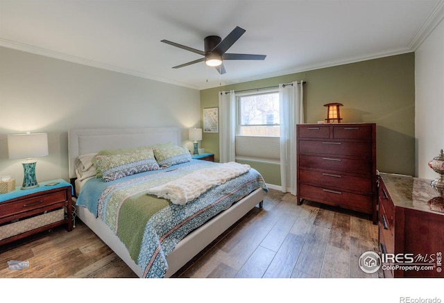 bedroom with a ceiling fan, wood finished floors, and crown molding