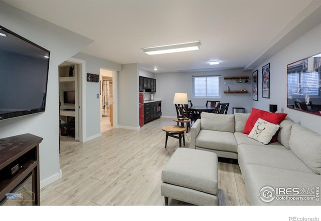 living area featuring baseboards and light wood-style floors