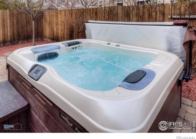 exterior space with a hot tub and fence