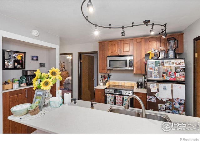 1315 Kirkwood Dr Unit 804, Fort Collins, CO 80525 - kitchen featuring brown cabinetry, light countertops, a sink, and stainless steel appliances