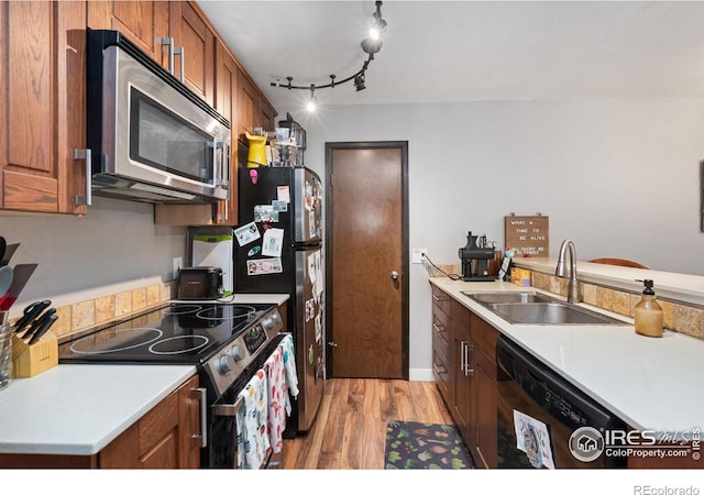 1315 Kirkwood Dr Unit 804, Fort Collins, CO 80525 - kitchen with light countertops, a sink, appliances with stainless steel finishes, brown cabinets, and light wood-type flooring