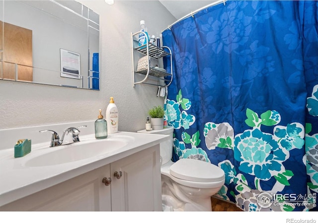 1315 Kirkwood Dr Unit 804, Fort Collins, CO 80525 - full bathroom featuring toilet, curtained shower, vanity, wood finished floors, and a textured wall