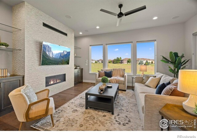 5977 Crooked Stick Dr, Windsor, CO 80550 - living area with wood finished floors, a ceiling fan, a large fireplace, and recessed lighting