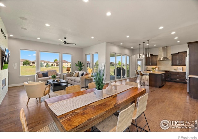 5977 Crooked Stick Dr, Windsor, CO 80550 - dining area featuring recessed lighting, wood finished floors, a ceiling fan, and a glass covered fireplace