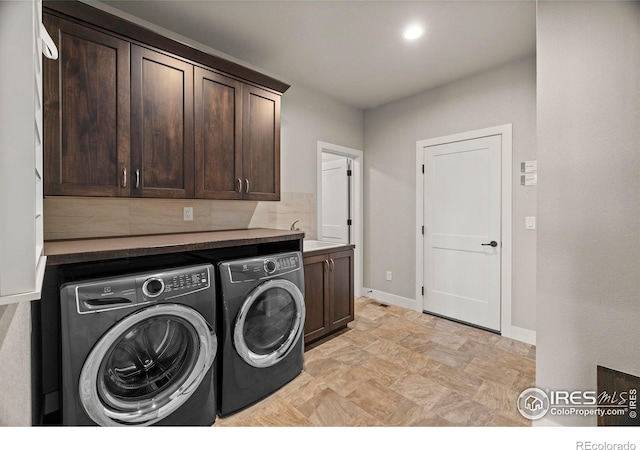 5977 Crooked Stick Dr, Windsor, CO 80550 - washroom featuring cabinet space, washer and clothes dryer, and stone finish floors