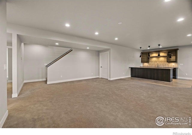 5977 Crooked Stick Dr, Windsor, CO 80550 - unfurnished living room with recessed lighting, wet bar, light colored carpet, and stairs