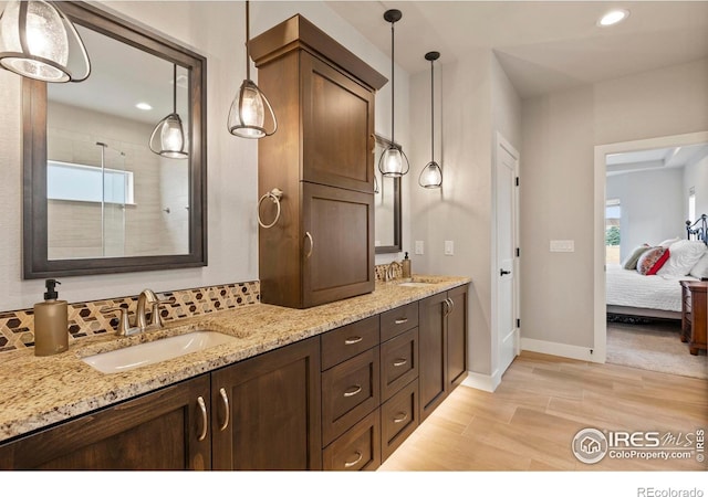 5977 Crooked Stick Dr, Windsor, CO 80550 - ensuite bathroom with double vanity, recessed lighting, and wood finished floors
