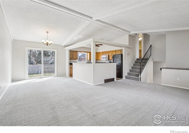 unfurnished living room featuring a textured ceiling, vaulted ceiling with beams, a notable chandelier, and light colored carpet