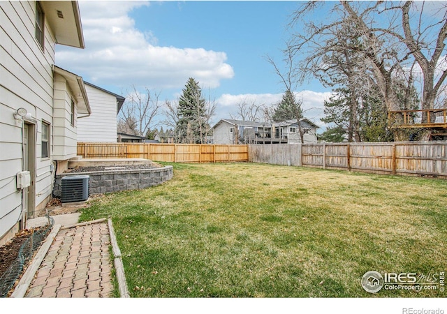 view of yard with a fenced backyard and central AC unit