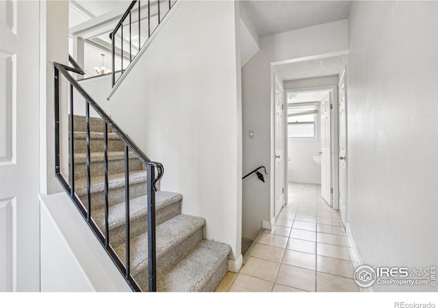stairs with baseboards and tile patterned flooring