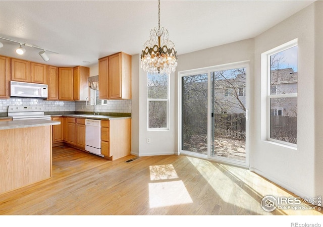 kitchen featuring white appliances, light wood-style flooring, and decorative backsplash