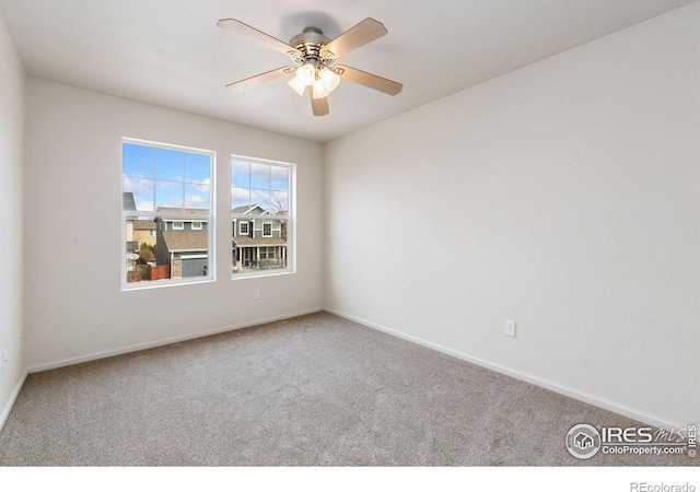 spare room with a ceiling fan, carpet floors, and baseboards