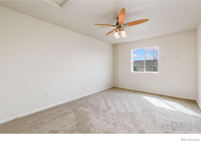 empty room featuring carpet flooring, a ceiling fan, and baseboards