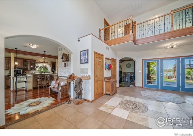 4514 Hoot Owl Dr, Berthoud, CO 80513 - foyer entrance featuring arched walkways, a high ceiling, light tile patterned flooring, and baseboards
