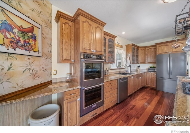 4514 Hoot Owl Dr, Berthoud, CO 80513 - kitchen with appliances with stainless steel finishes, dark wood-type flooring, light stone countertops, brown cabinetry, and recessed lighting