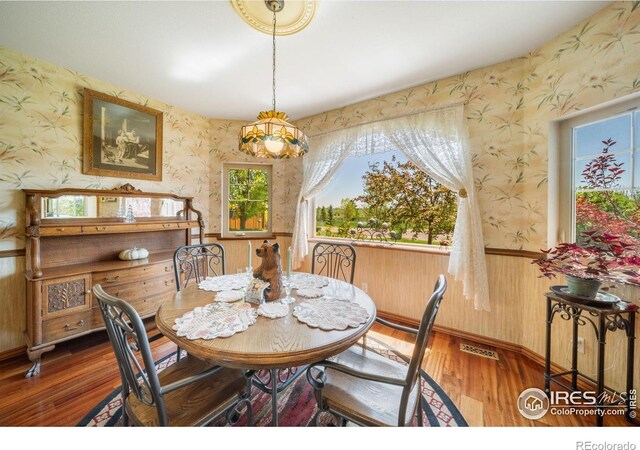 4514 Hoot Owl Dr, Berthoud, CO 80513 - dining space with wallpapered walls, wood finished floors, and wainscoting
