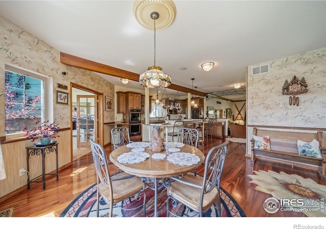 4514 Hoot Owl Dr, Berthoud, CO 80513 - dining area with wallpapered walls, light wood-style flooring, a wainscoted wall, baseboards, and beam ceiling
