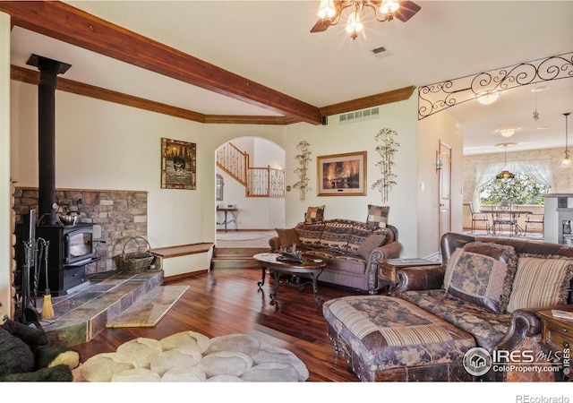 4514 Hoot Owl Dr, Berthoud, CO 80513 - living area featuring wood-type flooring, ceiling fan, arched walkways, a wood stove, and beam ceiling