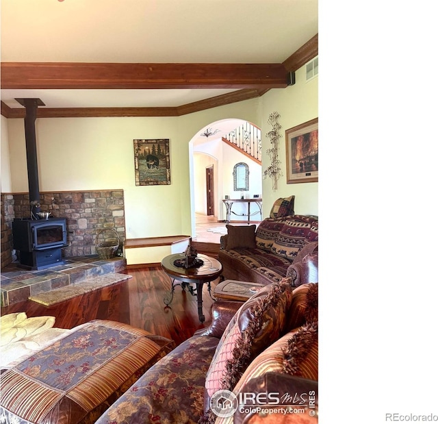 4514 Hoot Owl Dr, Berthoud, CO 80513 - living area with beam ceiling, wood finished floors, arched walkways, a wood stove, and baseboards