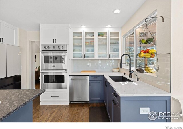 501 W Linden St, Louisville, CO 80027 - kitchen with glass insert cabinets, a sink, stainless steel appliances, and tasteful backsplash