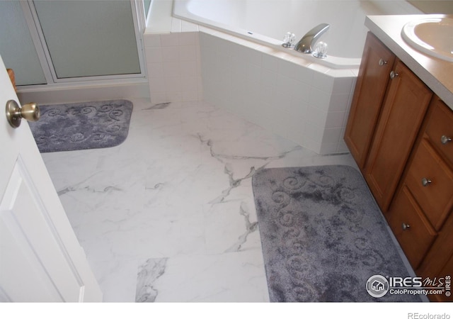 5750 W 20th St Unit 17-2, Greeley, CO 80634 - bathroom with vanity, a garden tub, marble finish floor, and a shower stall